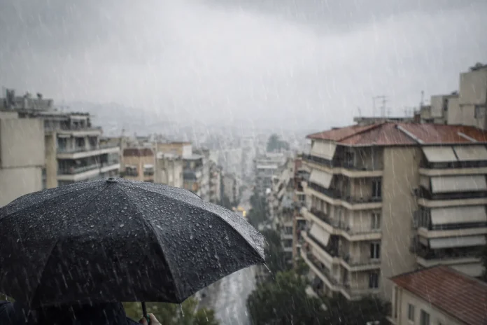 Άτομο με ομπρέλα σε βροχερό αστικό τοπίο με γκρίζο ουρανό και βρεγμένους δρόμους.