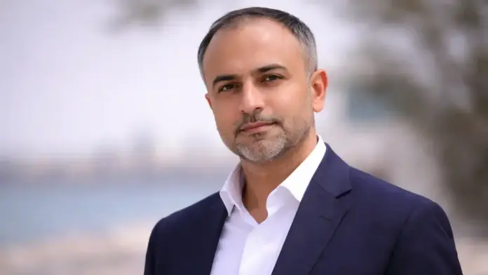 Editorial portrait of Indian journalist Aditya Raj Kaul in a formal outdoor setting.
